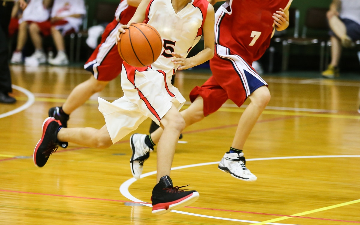 Basketball player dribbling down court during game