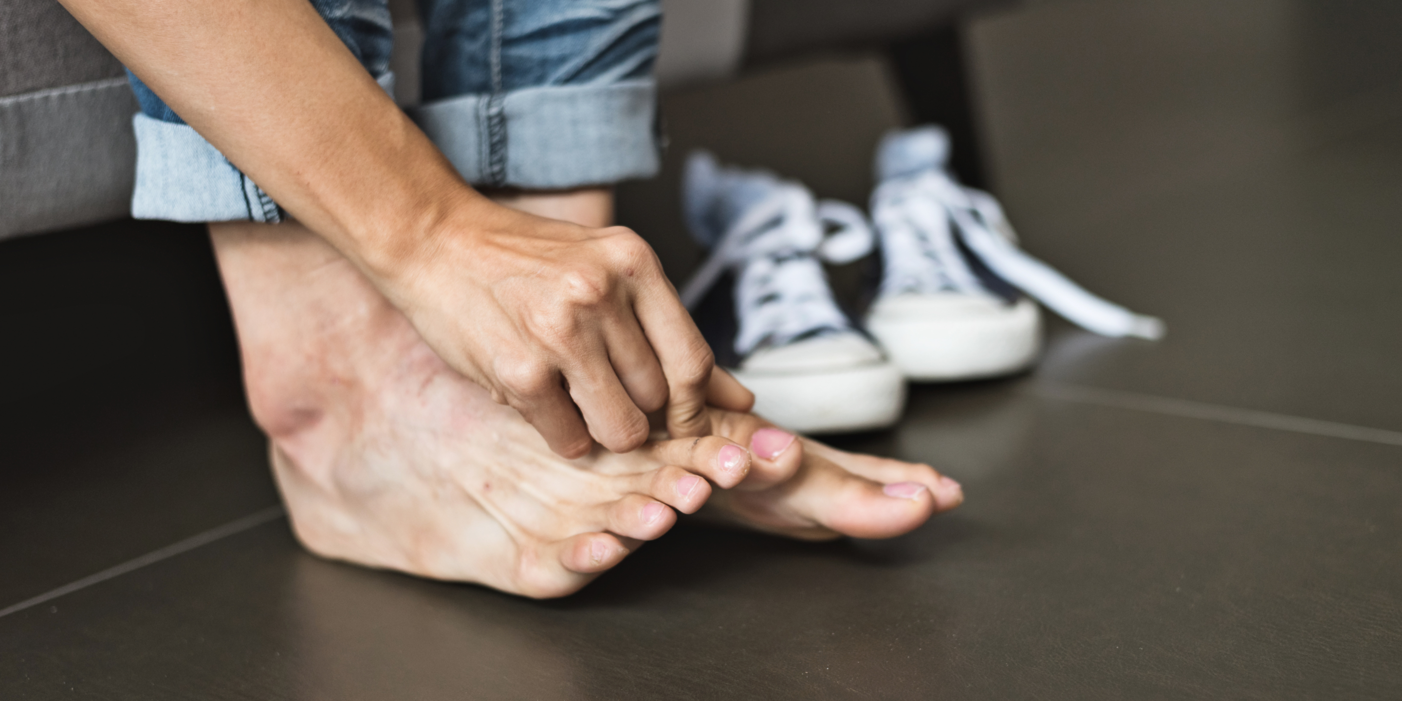 woman touching painful big toe